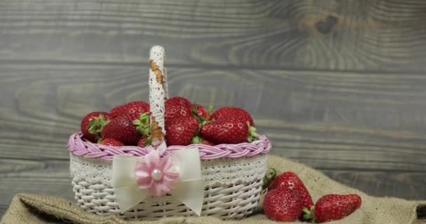 Strawberries in a small basket on the wooden table - close up — Stock Video