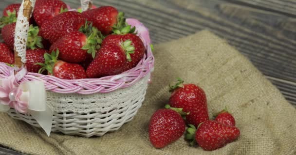 Strawberries in a small basket on the wooden table - close up — Stock Video