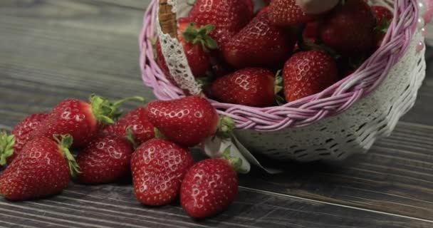 Las fresas en una pequeña canasta sobre la mesa de madera - de cerca — Vídeo de stock