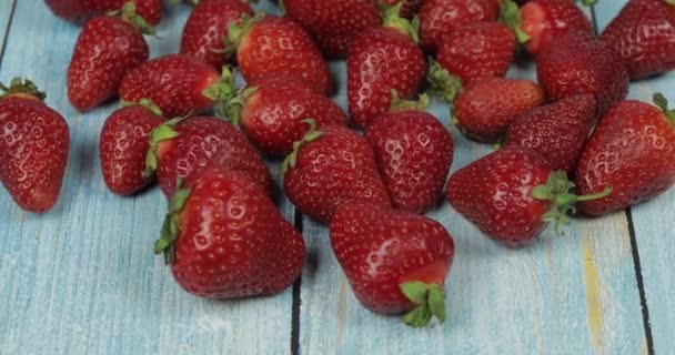 Strawberries on the blue wooden table - close up. Fresh ripe red organic berries — Stock Video