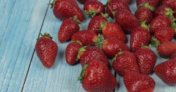 蓝色木桌上的草莓 - 特写。新鲜成熟的红色有机浆果 — 图库视频影像
