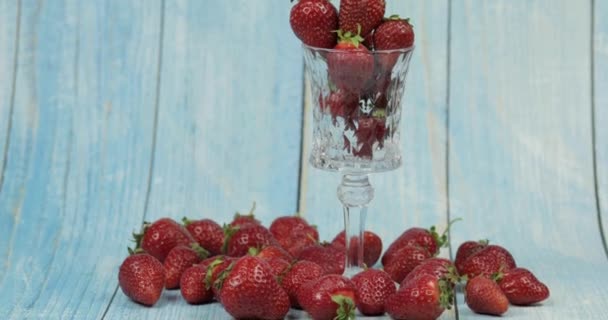 Fresas en vaso sobre mesa de madera azul. Mens mano toma una baya — Vídeos de Stock