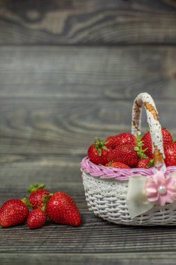 Ahşap masada küçük bir sepet çilek. Logonuz veya metin için yer