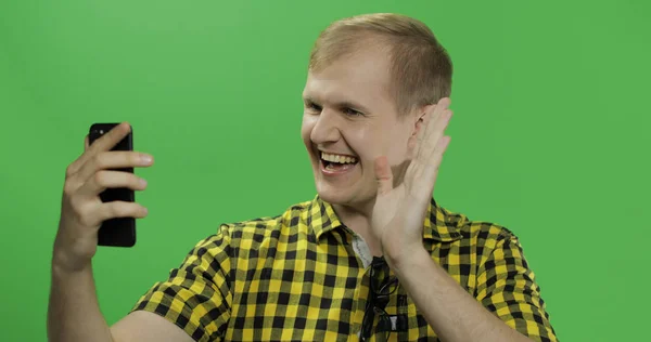 Caucásico joven en camisa amarilla usando teléfono móvil para videollamada — Foto de Stock