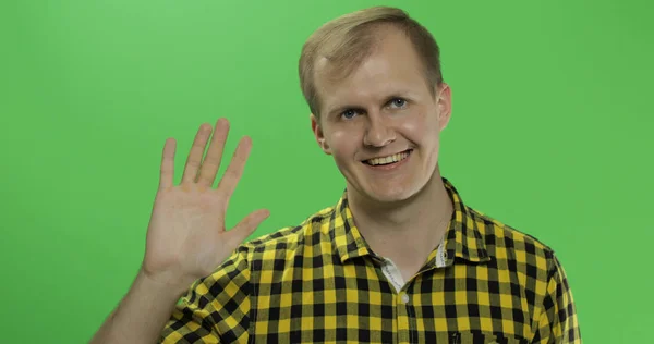 Guapo caucásico hombre olas y saludo en verde pantalla croma clave — Foto de Stock