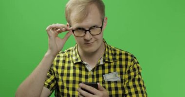 Gözlük beyaz adam kaydırma veya elinde akıllı telefonda manifatura.