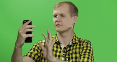 Video araması için cep telefonu kullanarak sarı gömlek Kafkas genç adam