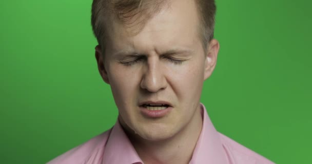 Gesicht eines jungen depressiven Mannes weint auf grünem Hintergrund — Stockvideo