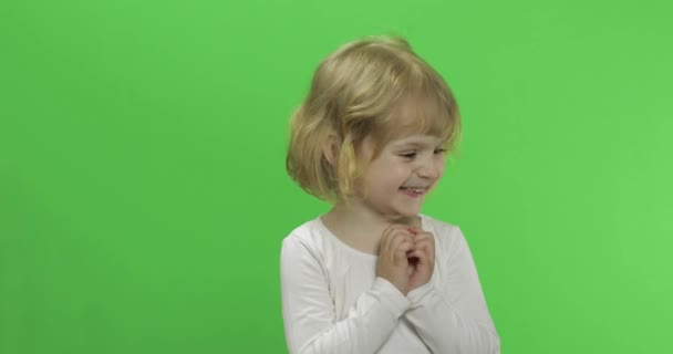 Χαρούμενη μικρή ξανθιά με λευκό μπλουζάκι. Χαριτωμένο ξανθό παιδί. Κάνοντας πρόσωπα — Αρχείο Βίντεο