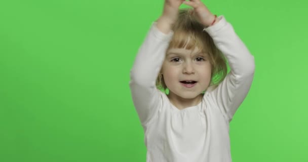 Šťastná malá blondýnka v bílým tričku. Roztomilé blonďaté dítě. Tleskání v rukou — Stock video