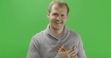 Gri kazakgiyen yakışıklı genç adam aşk jesti yapıyor. Renk anahtarı