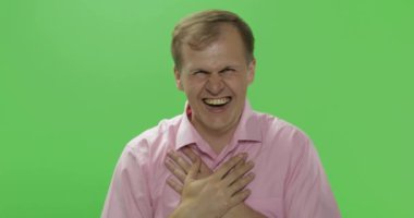 Pembe gömlekli yakışıklı genç adam gülüyor. Renk anahtarı