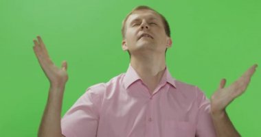 Pembe gömlekli yakışıklı genç adam dua ediyor. Renk anahtarı