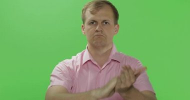 Pembe gömlekli yakışıklı genç adam el çırpıyor. Renk anahtarı