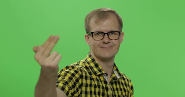 Handsome young man in yellow shirt doing doing coming gesture. Chroma key — Stock Video
