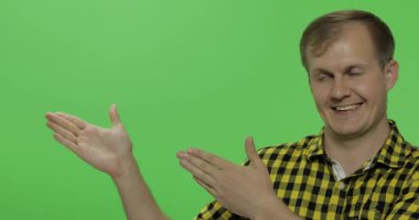 Sarı gömlekli beyaz adam bir şeyler gösteriyor. Logonuz veya metniniz için yerleştirin