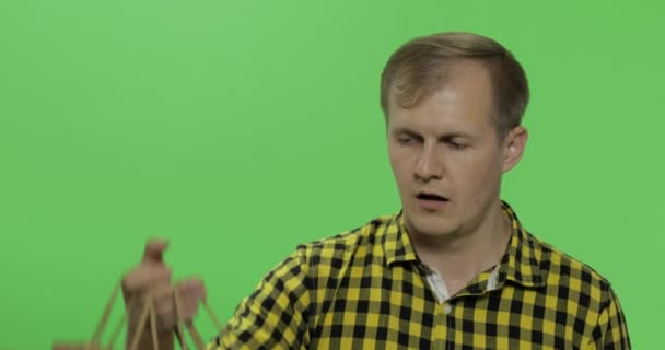 Gelangweilte junge Mann auf grünem Bildschirm Chroma-Schlüssel Hintergrund mit Einkaufstaschen — Stockvideo