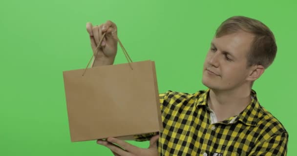 Young man on green screen chroma key background with shopping bag — Stock Video