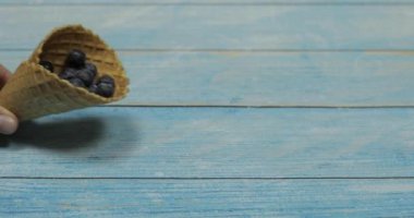 Berry dondurma. Mavi ahşap arka plan üzerinde bir waffle yaban mersini çilek