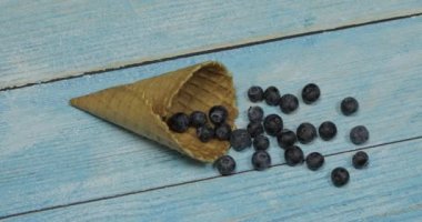 Berry dondurma. Mavi ahşap arka plan üzerinde bir waffle yaban mersini çilek
