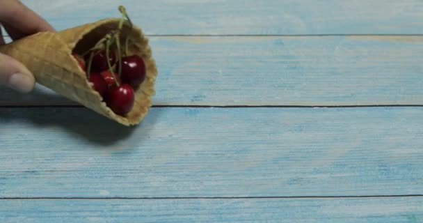 Berry ice cream. Berries of cherry in a waffle on a blue wooden background — Stock Video