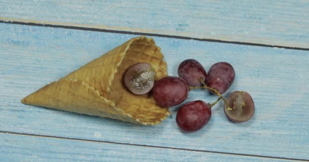 Berry-ijs. Bessen van druiven in een wafel op een blauwe houten achtergrond — Stockvideo