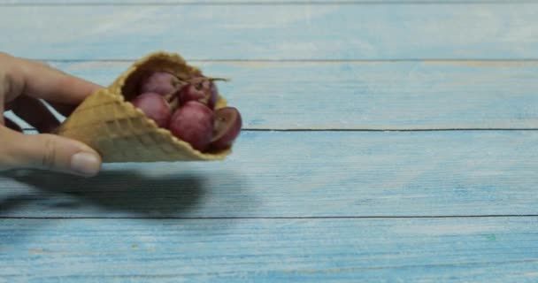 ベリーアイスクリーム青い木製の背景にワッフルのブドウの果実 — ストック動画