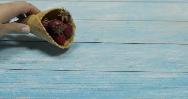 Lody jagodowe. Jagody truskawek w waflu na niebieskim tle drewnianym — Wideo stockowe