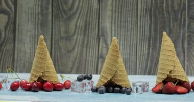 Meyve ve meyveli dondurma. Yaban mersini, çilek, waffle konisinde kiraz