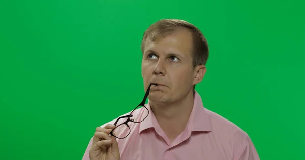 Gutaussehender, nachdenklicher Mann im rosafarbenen Hemd denkt über etwas nach. Chroma-Schlüssel — Stockfoto
