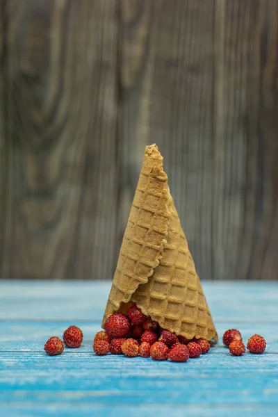 Helado de bayas. Fresa en un cono de gofre sobre fondo de madera — Foto de Stock