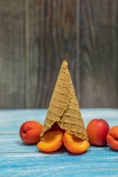 Helado de frutas. Albaricoque en un cono de gofre sobre fondo de madera — Foto de Stock