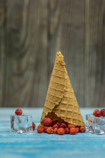 Helado de bayas. Fresa en un cono de gofre sobre fondo de madera — Foto de Stock