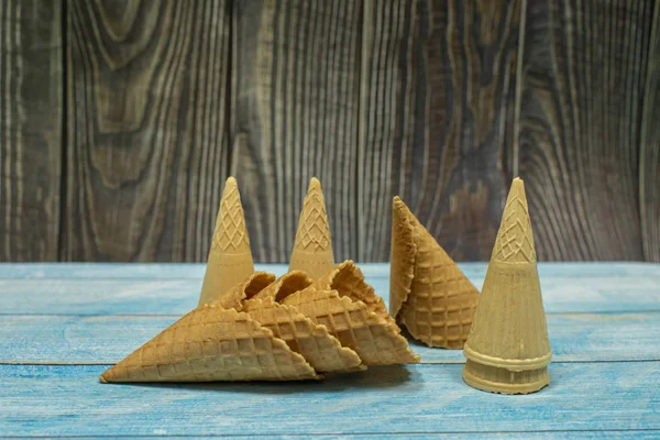 Conos de helado, aislados sobre una superficie de madera azul. Gofres para helado —  Fotos de Stock