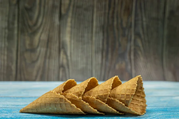 Conos de helado, aislados sobre una superficie de madera azul. Gofres para helado — Foto de Stock
