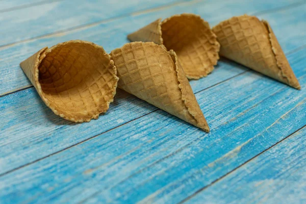 Conos de helado, aislados sobre una superficie de madera azul. Gofres para helado — Foto de Stock