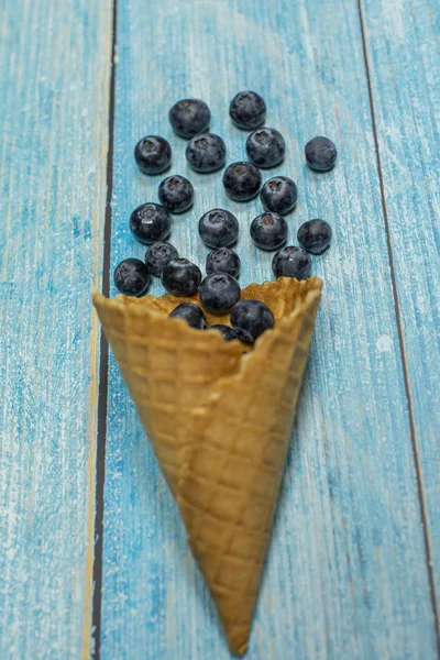 Helado de bayas. Bayas de arándanos en un gofre sobre un fondo de madera azul — Foto de Stock