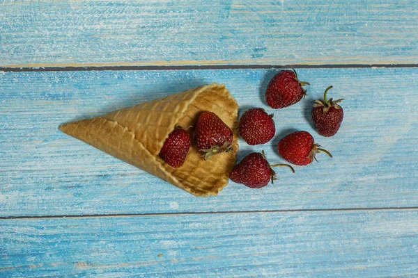 Helado de bayas. Bayas de fresa en un gofre sobre un fondo de madera azul — Foto de Stock