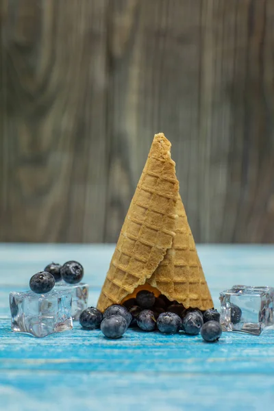 Helado de bayas. Arándano en un cono de gofre sobre fondo de madera — Foto de Stock