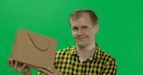 緑の画面上の若い男クロマキー背景でショッピングバッグ — ストック写真