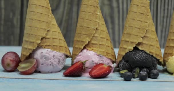 ワッフルコーンのボールに甘いアイスクリーム。異なる味のベリーや果物 — ストック動画