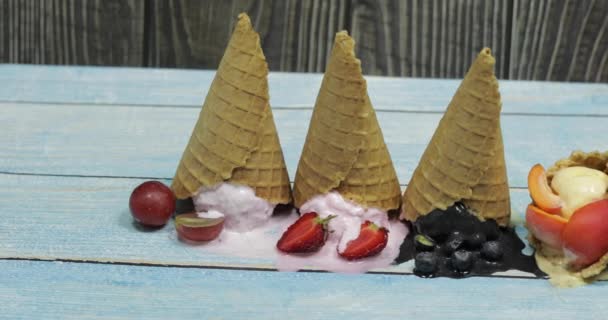 Сладкие расплавленные шарики мороженого в вафельном конусе. Различные ягоды и фрукты — стоковое видео