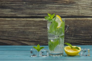 Yeşil nane yaprakları ve buz küpleri ile cam berrak su