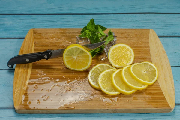 Diiris lemon, es batu, daun mint segar untuk mojito cocktail di papan potong — Stok Foto