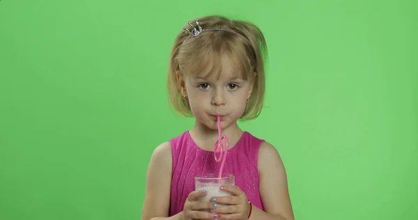 Šťastné čtyři roky staré dítě v růžových šatech pije mléčný koktejl. Klíč Chroma — Stock fotografie