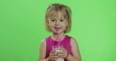 Pembe elbiseli mutlu dört yaşındaki çocuk milkshake kokteyli içer. Renk Anahtarı