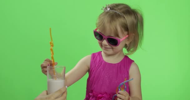 ピンクのドレスを着た幸せな4歳の子供はミルクセーキカクテルを飲みます。クロマキー — ストック動画