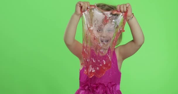 Kinder haben Spaß dabei, roten Schleim zu machen. Kind spielt mit handgemachtem Spielzeugschleim — Stockvideo