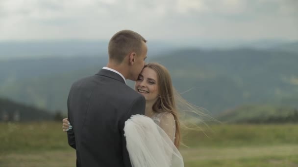 Groom avec mariée s'amuser sur une colline de montagne. Couple de mariage câlin — Video