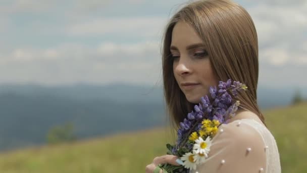 Close up shot of brides face. Bride in wedding dress stay with bouquet — Stock Video